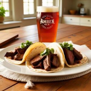 s Beer Braised Steak Tacos on a white plate and a beer on a table in a home kitchen